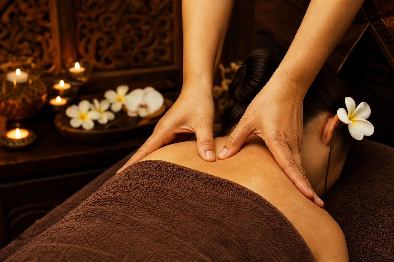Therapist working along a guest's shoulder during a massage